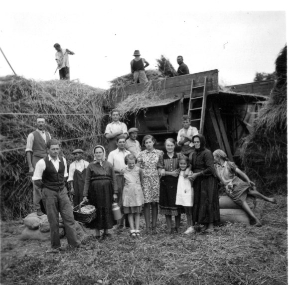 Ezen a képen jobban látszik maga a cséplőgép, tetején a munkásokkal.