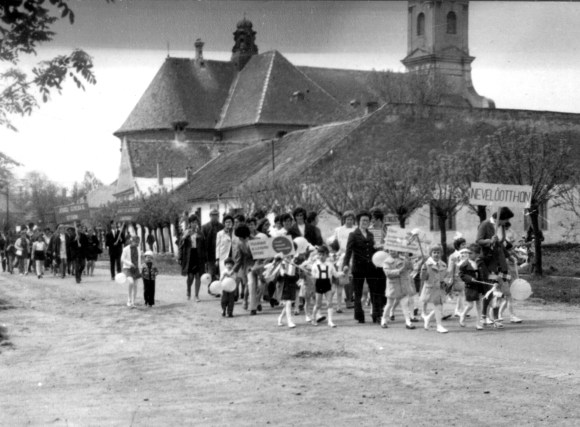 Az állami gondozottak nevelőikkel vonulnak. Még hiányzik a tömbház jobb kéz felől.