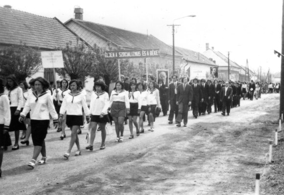 Éljen a szocializmus és a béke! Az eleki gimnazisták a pékség, illetve az egykori Zöldfa Vendéglő előtt. Utóbbi helyén napjainkban a szociális bérlakások társasháza áll.